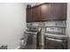 Modern laundry room with stainless steel washer and dryer, cabinets, and open shelves at 115 Machrie Loop # D, Myrtle Beach, SC 29588