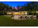 Backyard view with pool, lounge seating and bistro lights at twilight. The home's lights are reflecting into the pool at 116 Chapel Ridge Circle, Myrtle Beach, SC 29588