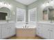 Bright bathroom features a corner tub, dual sinks and a window with frosted glass for privacy at 116 Chapel Ridge Circle, Myrtle Beach, SC 29588