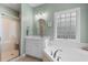 This bathroom features a walk-in shower, corner tub and a frosted glass window for privacy at 116 Chapel Ridge Circle, Myrtle Beach, SC 29588
