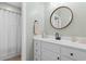 Neutral bathroom features a white vanity, shower with curtain, and a round mirror above the sink at 116 Chapel Ridge Circle, Myrtle Beach, SC 29588