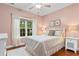 Cozy bedroom with pink walls features a plush bed, ample natural light, and hardwood floors at 116 Chapel Ridge Circle, Myrtle Beach, SC 29588