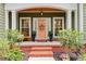 Inviting front porch with brick steps, decorative columns, bench, and a charming door with a seasonal wreath at 116 Chapel Ridge Circle, Myrtle Beach, SC 29588