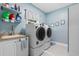 Well-lit laundry room boasts modern washer and dryer, sink, and shelving for storage at 116 Chapel Ridge Circle, Myrtle Beach, SC 29588