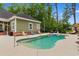Backyard pool with a concrete deck, lounge chairs and lush green trees surrounding the property at 116 Chapel Ridge Circle, Myrtle Beach, SC 29588