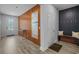 Modern entryway featuring wood accent wall, mirror, bench with pillows, and door to the outside at 1168 Baker Creek Loop, Myrtle Beach, SC 29579