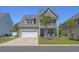 Charming two-story home features a two-car garage, upper balcony, and mature landscaping with palm trees at 1168 Baker Creek Loop, Myrtle Beach, SC 29579