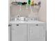 Bright laundry room showcasing a modern, white washer and dryer set with overhead shelving at 1170 Maxwell Dr., Little River, SC 29566