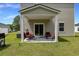 Covered patio with comfortable seating, ideal for outdoor dining and relaxing in a well-manicured backyard at 120 Carolina Lakes Blvd., Myrtle Beach, SC 29588