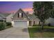 Charming home at twilight featuring a two-car garage, well-kept lawn, and mature tree providing ample shade at 140 Avondale Dr., Myrtle Beach, SC 29588