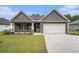 This exterior shot of the home shows the 2-car garage, complementary siding, and driveway at 1476 Burriss Rd., Conway, SC 29526