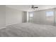 A large bedroom with light walls, carpeted floor, a ceiling fan, and two large windows at 148 Long Leaf Pine Dr., Conway, SC 29526