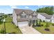 Two-story home featuring neutral siding, black shutters, lush lawn, landscaping, and a long driveway leading to the garage at 148 Long Leaf Pine Dr., Conway, SC 29526