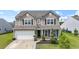 Charming two-story home with neutral siding, black shutters, manicured landscaping, and an attached two-car garage at 148 Long Leaf Pine Dr., Conway, SC 29526