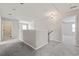 Bright hallway with carpet, neutral walls, modern lighting, and view of the upstairs loft at 148 Long Leaf Pine Dr., Conway, SC 29526