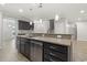 Close-up of kitchen island with granite countertop, stainless steel dishwasher, and dark wood cabinets with modern hardware at 148 Long Leaf Pine Dr., Conway, SC 29526