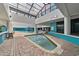 Indoor wading pool with tile accents, surrounded by brick flooring and lush greenery at 1501 Ocean Blvd. S # 1249, Myrtle Beach, SC 29577