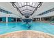 Large indoor pool with tiered fountain, glass roof and expansive views of pool area and lounge chairs at 1501 Ocean Blvd. S # 1249, Myrtle Beach, SC 29577