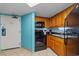 Galley kitchen features wooden cabinets, black appliances, granite countertops, and a colorful backsplash at 1501 Ocean Blvd. S # 1249, Myrtle Beach, SC 29577