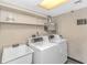 Functional laundry room area with sink, shelving, washer, and dryer at 1605 S Ocean Blvd. S # 105, Myrtle Beach, SC 29577