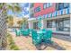 Outdoor patio area featuring blue Adirondack chairs and umbrella near the building at 1605 S Ocean Blvd. S # 105, Myrtle Beach, SC 29577