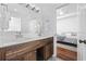 Bright bathroom with wood vanity, double sinks, and quartz countertop, leading to the bedroom at 196 La Patos Dr., Myrtle Beach, SC 29588