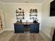 Stylish bar area with custom cabinetry, open shelving, beverage cooler, and elegant decor at 200 Ponte Vedra Dr., Murrells Inlet, SC 29576