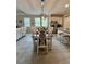 Bright dining room features stylish light fixture, a wood table, and seating for eight next to the open kitchen at 200 Ponte Vedra Dr., Murrells Inlet, SC 29576