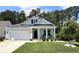Charming one-story home with a manicured lawn, white garage door, and inviting front porch with rocking chairs at 200 Ponte Vedra Dr., Murrells Inlet, SC 29576