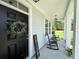 Inviting front porch with rocking chairs and a decorative wreath on the black front door at 200 Ponte Vedra Dr., Murrells Inlet, SC 29576