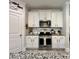 Modern kitchen featuring white cabinets, stainless steel appliances, granite countertops, and a stylish backsplash at 200 Ponte Vedra Dr., Murrells Inlet, SC 29576
