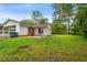 Exterior view of the home showcasing a well-maintained lawn, a patio, and a white-and-red brick exterior at 203 Longwood Ln., Conway, SC 29527
