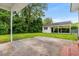 Spacious backyard with a concrete patio and a detached garage, surrounded by lush greenery and trees at 203 Longwood Ln., Conway, SC 29527