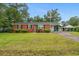 Charming brick home featuring manicured lawn, carport, and an American flag, perfect curb appeal at 203 Longwood Ln., Conway, SC 29527