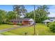 Charming brick home featuring a manicured lawn, carport, outbuilding, and classic American flagpole at 203 Longwood Ln., Conway, SC 29527