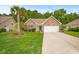 Charming brick home featuring a two-car garage, a well-manicured lawn, and mature landscaping at 231 Marbella Dr., Murrells Inlet, SC 29576