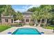 Gorgeous two-story home surrounded by palm trees, with a pool and inviting outdoor seating at 2382 Waverly Rd., Pawleys Island, SC 29585