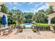 Beautiful backyard area featuring a pool, palm trees, lounge furniture, and an outdoor dining area at 2382 Waverly Rd., Pawleys Island, SC 29585