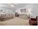 Spacious living room with neutral carpet, floral sofas, and bright natural light at 2448 Whetstone Ln., Myrtle Beach, SC 29579
