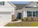 Close-up of home exterior with garage, blue shutters, and manicured landscaping around the front entry at 2609 Seaport Circle, Georgetown, SC 29440