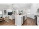Open-concept kitchen and living room with stainless appliances, white cabinets, and wood flooring at 2609 Seaport Circle, Georgetown, SC 29440