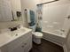 Well-lit bathroom featuring a vanity with sink, toilet, and a tub with a shower curtain at 304 S Magnolia Ave., Andrews, SC 29510