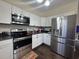 Modern kitchen featuring stainless steel appliances, dark countertops, and white cabinetry at 304 S Magnolia Ave., Andrews, SC 29510