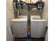 Functional laundry room features a washer, dryer, and overhead storage shelf for organization at 304 S Magnolia Ave., Andrews, SC 29510