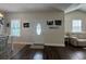 Spacious living area with white door, wood flooring, decorative paintings, and comfortable white sofa at 304 S Magnolia Ave., Andrews, SC 29510