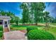 Expansive backyard with a lush lawn, mature trees, and a view of the golf course at 3334 Cedar Creek Run, Little River, SC 29566