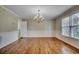 Formal dining area featuring hardwood floors, classic chandelier, and views to backyard at 3334 Cedar Creek Run, Little River, SC 29566