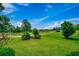 Scenic view of a lush golf course with manicured green grass and mature trees under a bright blue sky at 3334 Cedar Creek Run, Little River, SC 29566