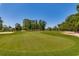 Beautifully manicured golf course with vibrant green fairway, sand traps, and mature trees under a clear blue sky at 3334 Cedar Creek Run, Little River, SC 29566