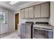 Functional laundry room with modern washer and dryer units, storage cabinets, and exterior access at 3334 Cedar Creek Run, Little River, SC 29566